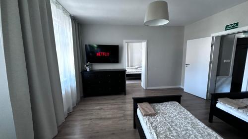 a living room with a tv and a bed in a room at Belgard- House 32 in Białogard