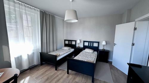a room with two beds and a window at Belgard- House 32 in Białogard