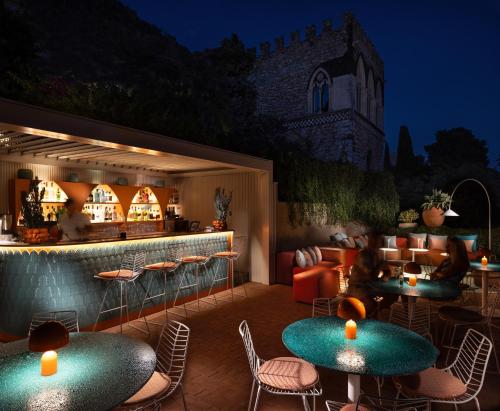 a patio with tables and chairs and a bar at Hotel Villa Taormina in Taormina