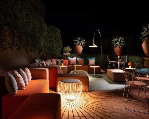 a lobby with orange couches and tables and plants at Hotel Villa Taormina in Taormina