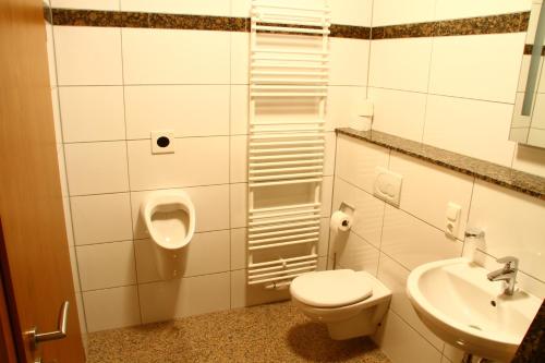 La salle de bains est pourvue de toilettes, d'un urinoir et d'un lavabo. dans l'établissement Bistro im Ring, à Quiddelbach