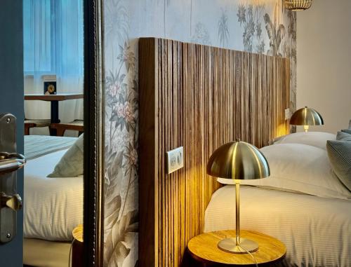 a bedroom with two beds and a mirror at Le Green des Impressionnistes in Ennery