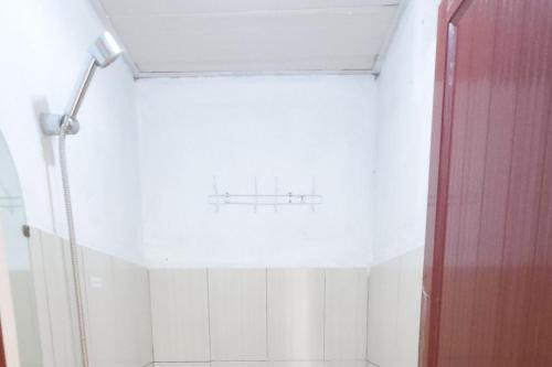 a bathroom with a shower with a red door at RedDoorz at Fortune Hotel Jalan Walanda Maramis Manado in Manado