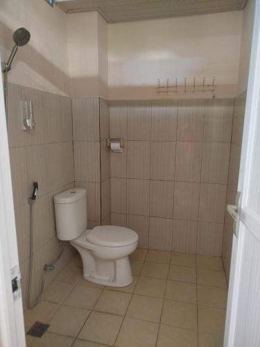 a small bathroom with a toilet and a shower at RedDoorz at Fortune Hotel Jalan Walanda Maramis Manado in Manado