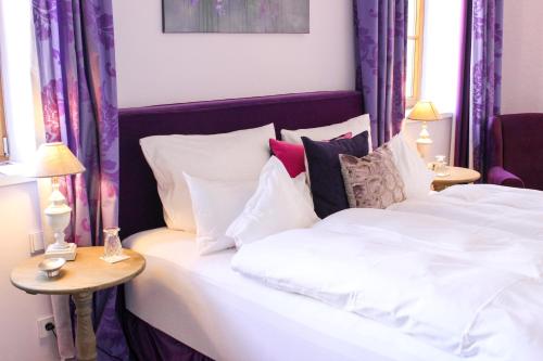 a bedroom with a bed with white sheets and pillows at Gästehaus im Weingut am Nil in Kallstadt