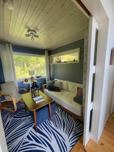 una sala de estar con un sofá y una mesa en Cozy and spacious vacation house by the sea, en Kemiönsaari