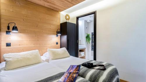 a bedroom with a white bed and a mirror at ASAI210-7-1 Appartement 4 étoiles - Les Saisies - 8 personnes in Les Saisies