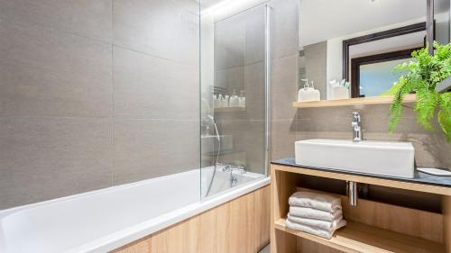 a bathroom with a bath tub and a sink at ASAI210-7-1 Appartement 4 étoiles - Les Saisies - 8 personnes in Les Saisies