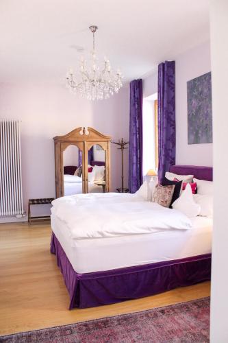 a bedroom with a large bed and a chandelier at Gästehaus im Weingut am Nil in Kallstadt