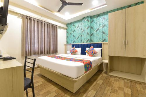 Un dormitorio con una cama grande en una habitación. en FabHotel Bhavna Palace, en Indore