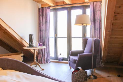 a bedroom with a chair and a lamp and a window at Gästehaus im Weingut am Nil in Kallstadt