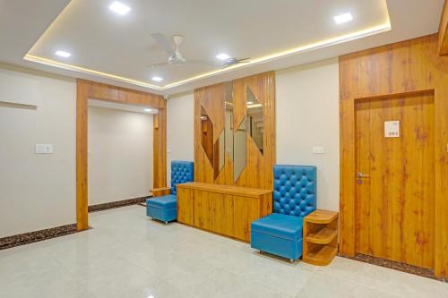 a room with two blue chairs and a door at FabHotel Aura Grande in Indore