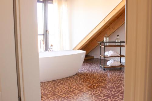 a bathroom with a white tub and a staircase at Gästehaus im Weingut am Nil in Kallstadt