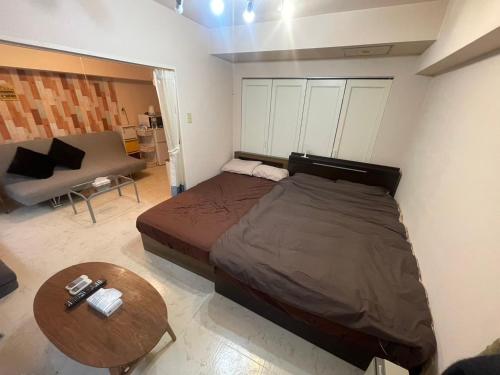 Un dormitorio con una cama, una mesa y un sofá. en RoseMarieSapporo, en Sapporo