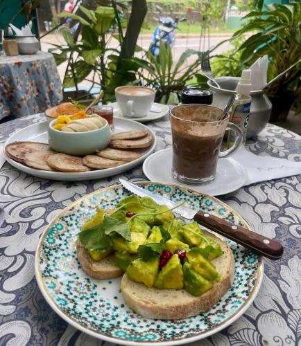 Una mesa cubierta con platos de comida y un sándwich. en Negombo Hiding Place, en Nikawatawana