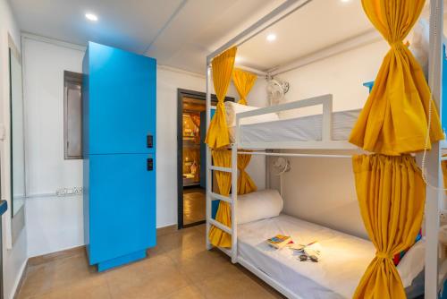 a room with bunk beds with yellow curtains at goSTOPS Mussoorie Clock Tower in Mussoorie