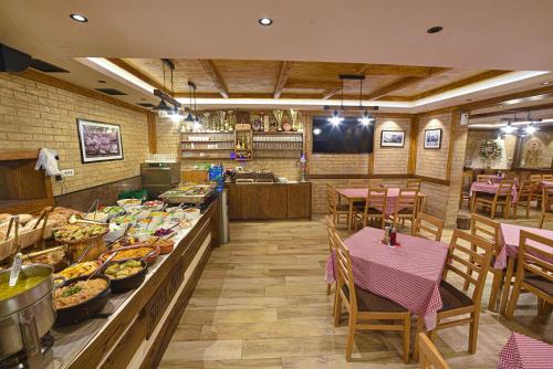 a restaurant with a buffet of food and tables at Vila Mina in Zlatibor