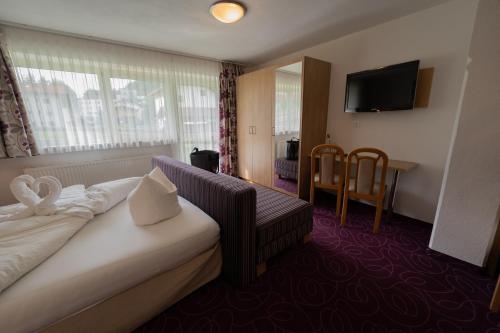 a hotel room with a bed and a television at Alpenpension Regina in Nauders