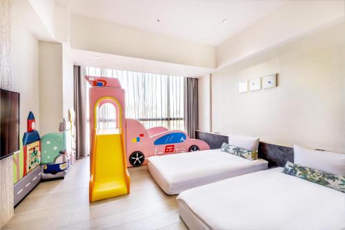 a childrens room with two beds and a play area at Hsin Hotel in Chiayi City