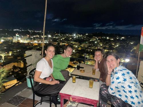 a group of people sitting at a table on a rooftop at Hostel Little Prince Home Stay in Jaisalmer