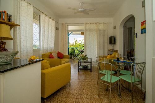 a living room with a yellow couch and a table at Residence Monte-Cristo in Anse Boileau