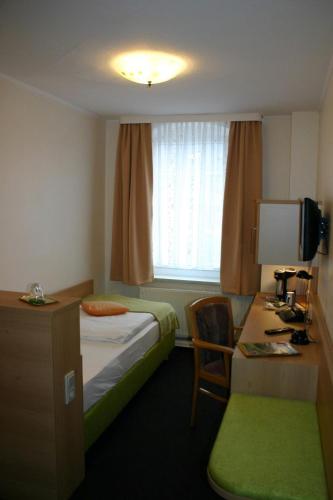 a hotel room with a bed and a desk and a window at Gasthof Dittmannsdorf in Olbernhau