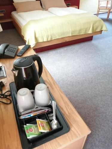 a tray with a tea pot and cups on a table in a bedroom at Gasthof Dittmannsdorf in Olbernhau