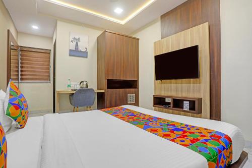 a bedroom with a bed and a desk and a tv at FabHotel Aura Grande in Indore
