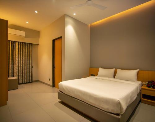 a bedroom with a large bed and a window at Palm Springs Resort in Nashik