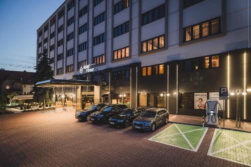 a group of cars parked in front of a building at Hotel Filmar in Toruń