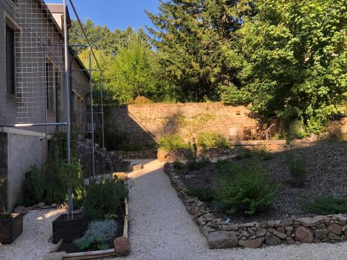 a garden with some plants and a building at Les gites du renard souriant in Cussy-en-Morvan