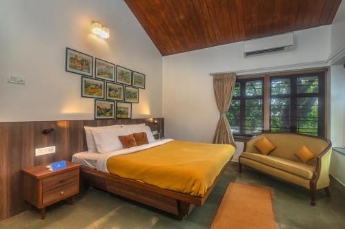 a bedroom with a bed and a chair at SaffronStays Hidden Branches -3BR pet-friendly villa with infinity pool & forest views in Khandala in Lonavala