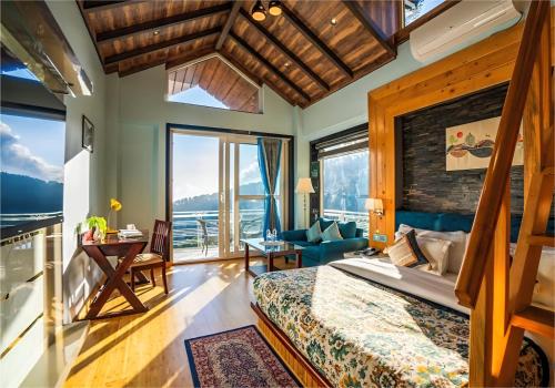 a bedroom with a bed and a large window at Jr Hotel Dharamshala in Dharamshala
