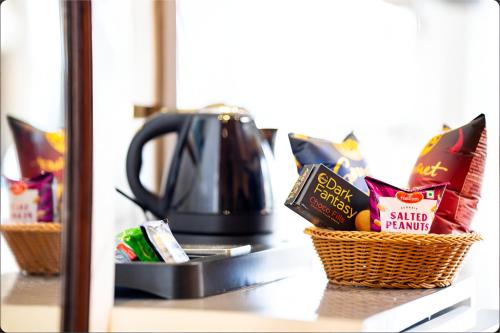 a counter with two baskets of food and a tea kettle at Jr Hotel Dharamshala in Dharamshala