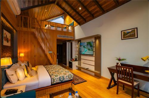 a bedroom with a bed and a desk and a television at Jr Hotel Dharamshala in Dharamshala
