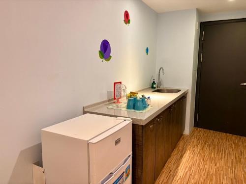 a kitchen with a white refrigerator and a sink at 閣樂親子旅宿Kids Fun Hotel in Luodong
