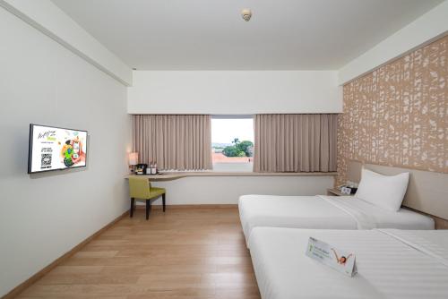 Postel nebo postele na pokoji v ubytování Whiz Prime Hotel Sudirman Cilacap