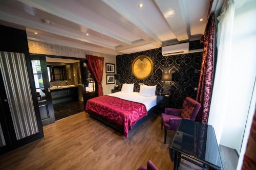 a hotel room with a bed and a purple chair at The Pavilions Amsterdam, The Toren in Amsterdam