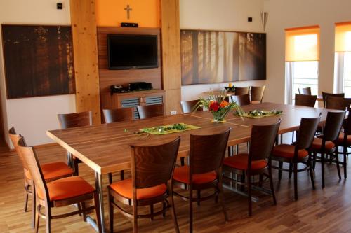 a dining room with a large wooden table and chairs at Schnatterhof in Lambrechten