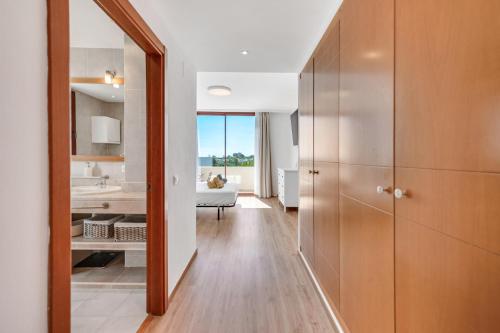ein Flur mit einem Badezimmer mit Waschbecken und Spiegel in der Unterkunft Villa Serena Marbella - Luxury villa with pool & sea views in Estepona