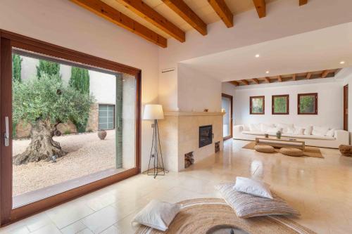 a living room with a fireplace and a large window at Empaltada in Selva