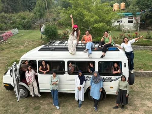 a group of people sitting on the top of a van at The Hood in Bīr