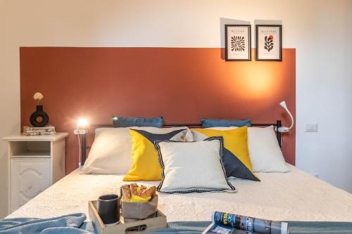 a bed with yellow and blue pillows on it at Residenza Il Torrione in Iesi