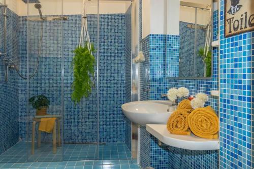 a blue tiled bathroom with a sink and a toilet and a sink at Residenza Il Torrione in Iesi