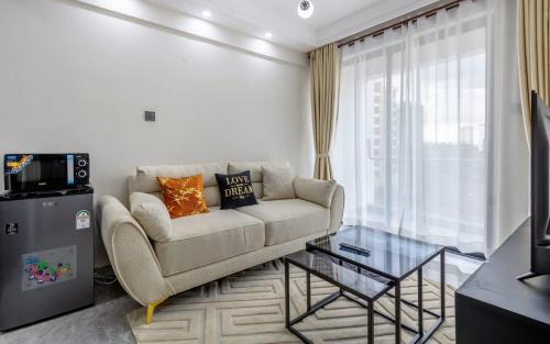 a living room with a couch and a television at Kilimani finest - One Bedroom Apartment in Nairobi