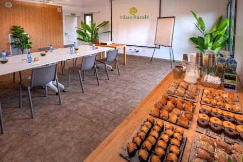 a large room with tables and chairs with pastries at Vilar Rural De Sant Hilari Sacalm by Serhs Hotels in Sant Hilari Sacalm