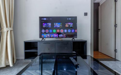 a living room with a tv and a glass table at Kilimani finest - One Bedroom Apartment in Nairobi