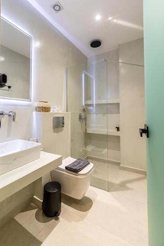 a bathroom with a toilet and a sink and a shower at Alkida Luxury Rooms Tolo in Tolo