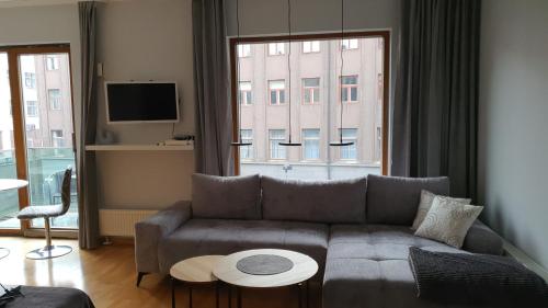 a living room with a couch and a large window at University City Heart, Tartu Home in Tartu