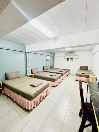 a room with four beds and a table at Patong Adventure Hostel in Patong Beach